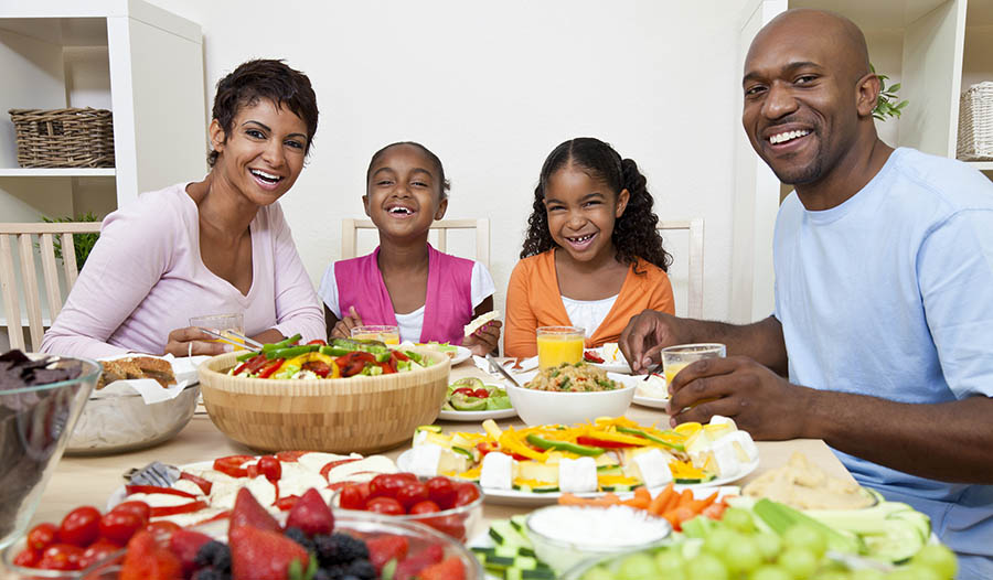 Family sitting at table eating healthy meal together