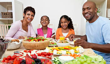 Family sitting at table eating healthy meal together