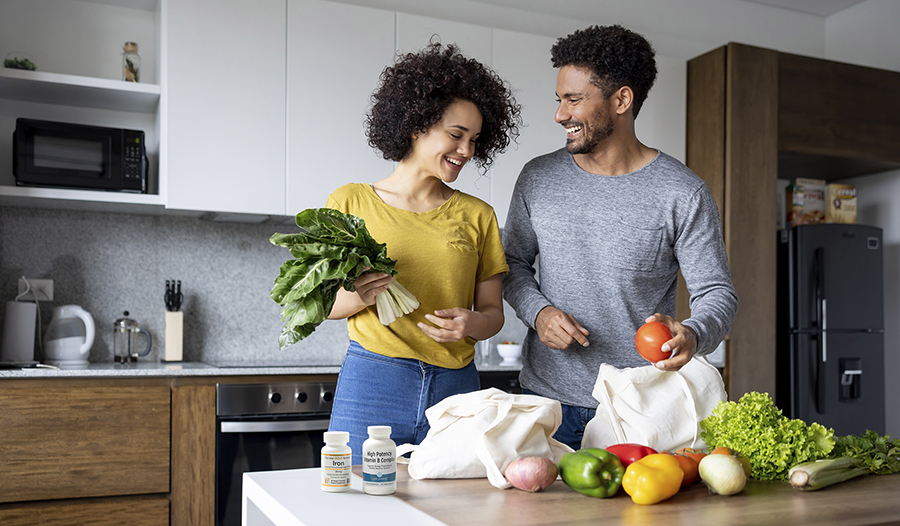 Couple unpacking healthy groceries at home in kitchen