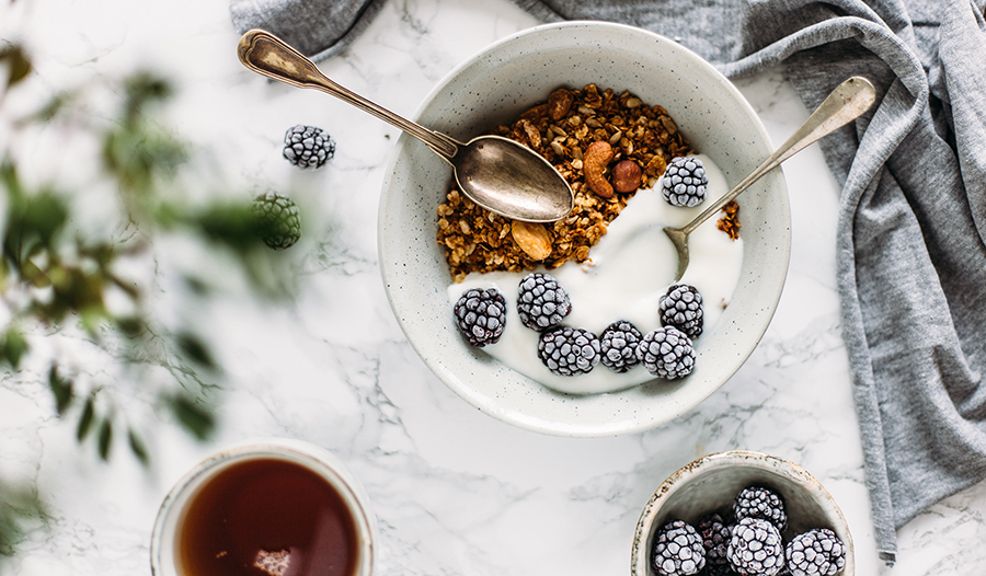 Yogurt with blackberries and granola on a marble table 