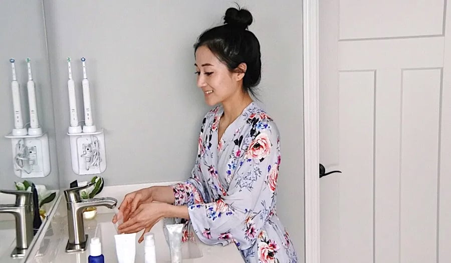 dermatologist in bathrobe in her bathroom showing nightly skincare routine