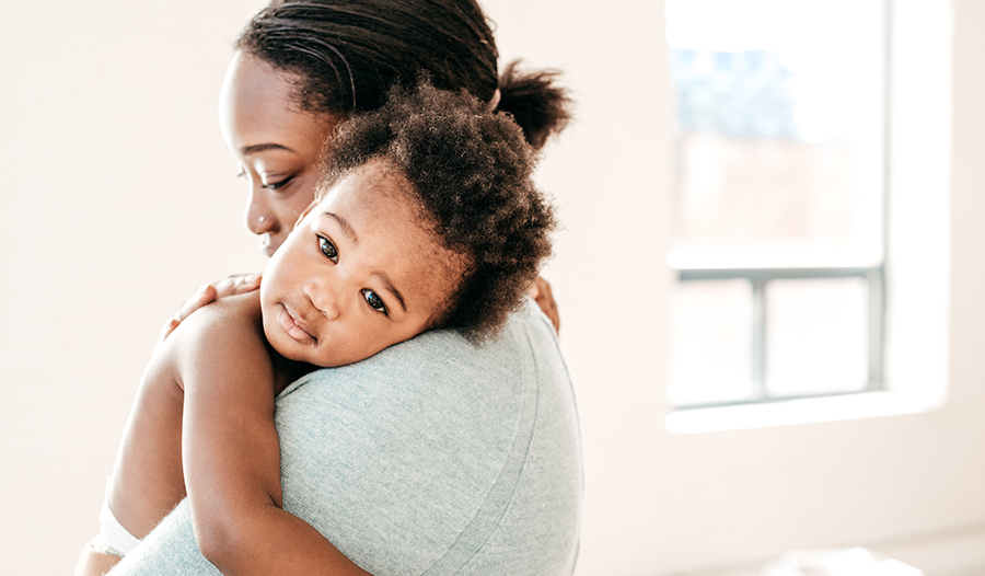 Beautiful mother with dark hair holding her baby 