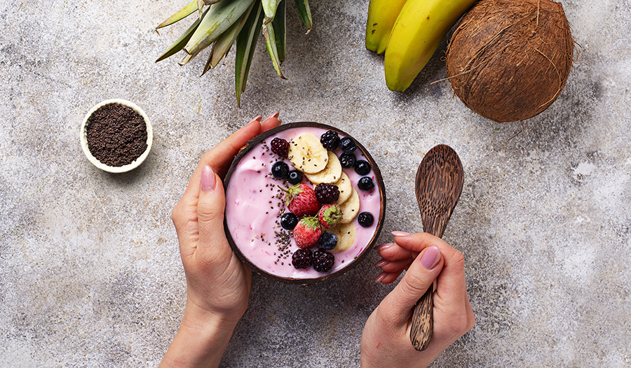 Acai smoothie bowl with fresh fruit toppings and chia seeds on concrete table