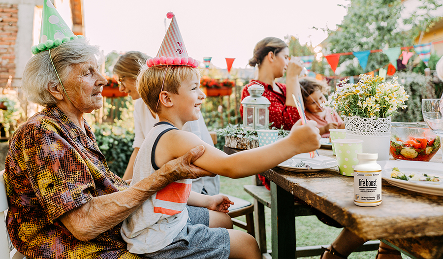 Outdoor family party with grandmother and grandson eating together