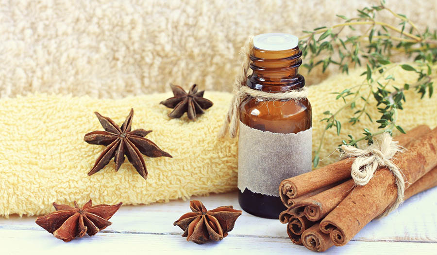 Cinnamon essential oil with towel and cinnamon cloves