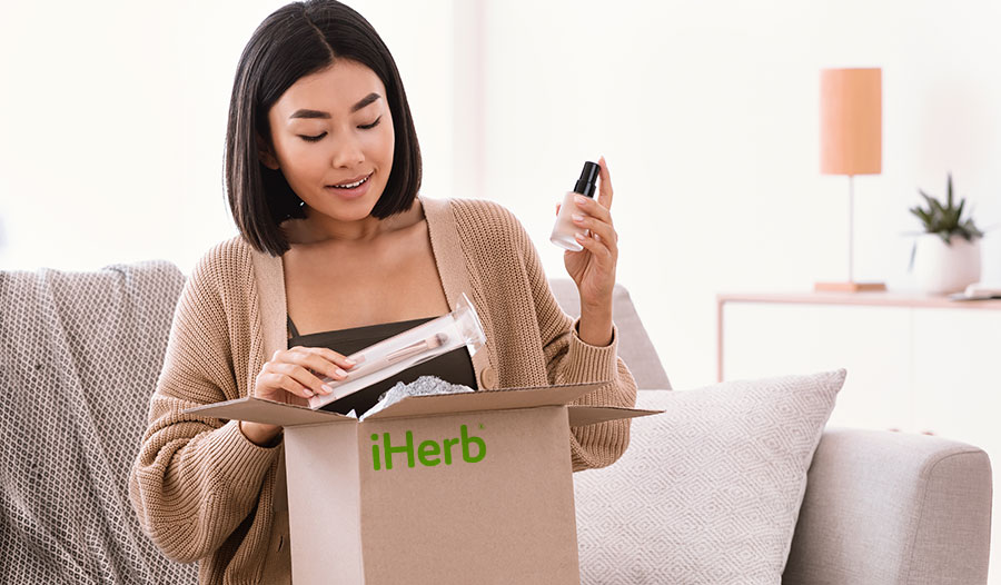 woman opening iHerb box of beauty products under $15