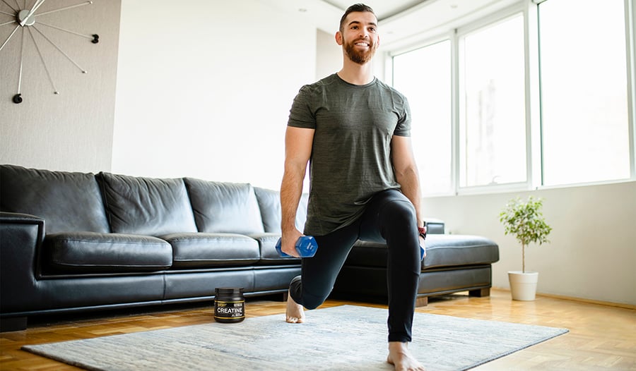 Athletic male working out in living room on yoga mat