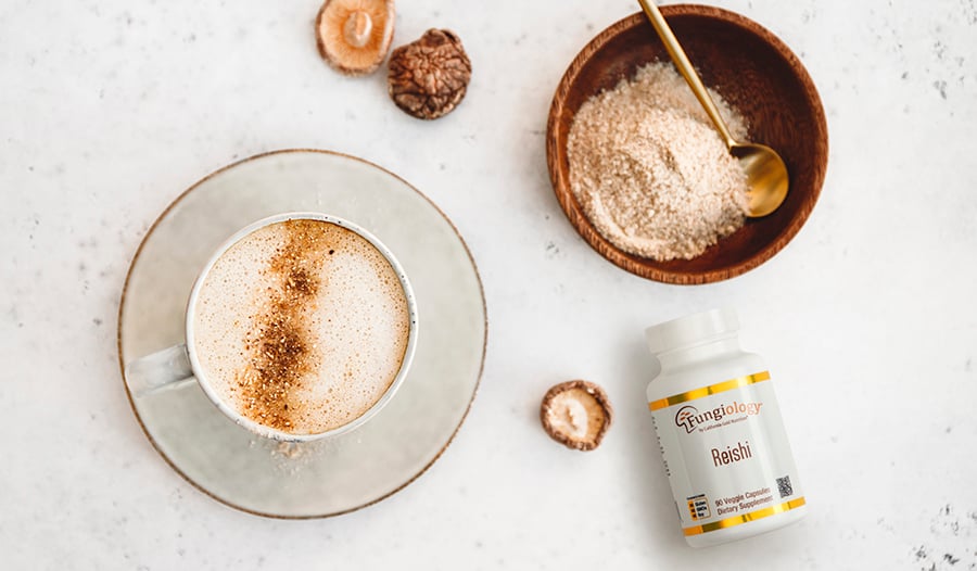 Mushroom supplement on table with coffee, mushrooms, and mushroom powder