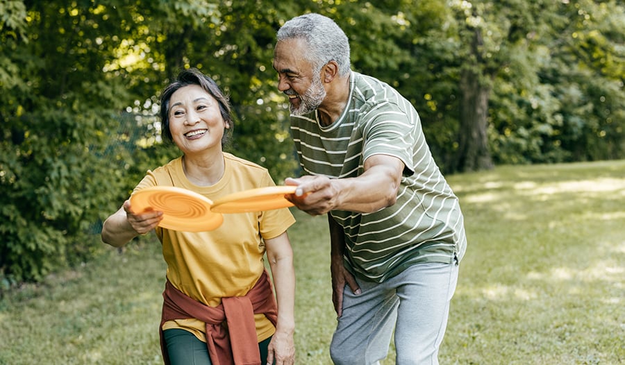 Healthy couple playing with frisbees outside