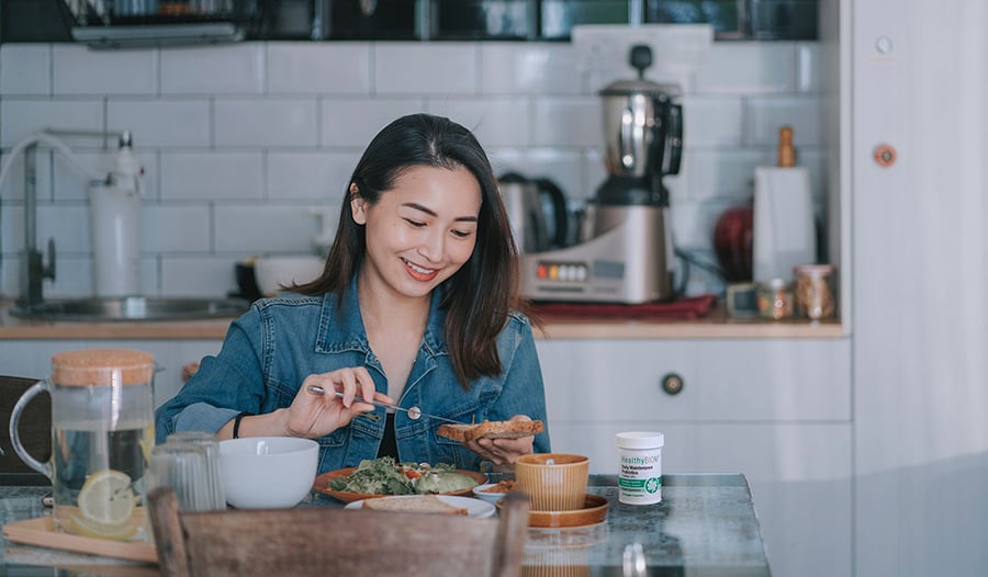 Woman eating gut healthy meal with probiotics at home