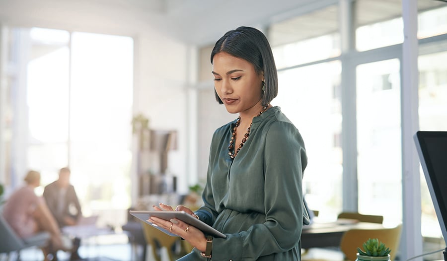 Asian woman in a business or school setting working on tablet