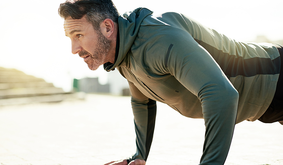 Mature man doing push ups outdoors 