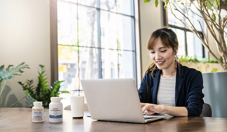 Woman working on computer by windows