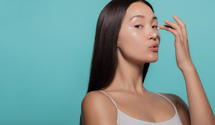 woman applying moisturizer with ceramides to face