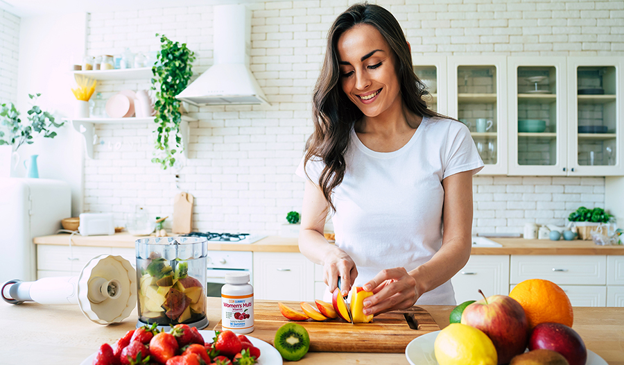 Young woman making a fruit smoothie in the kitchen