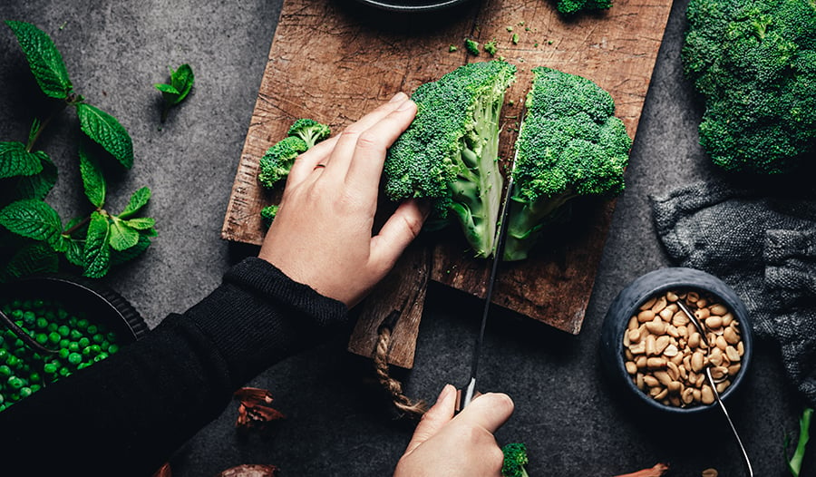 Broccoli and green vegetables on wooden board