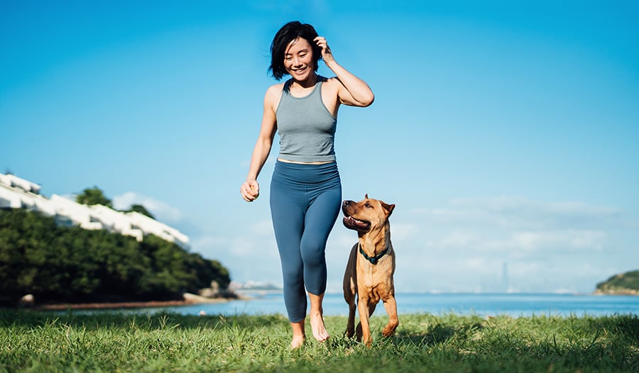 Woman with her dog on grassy field