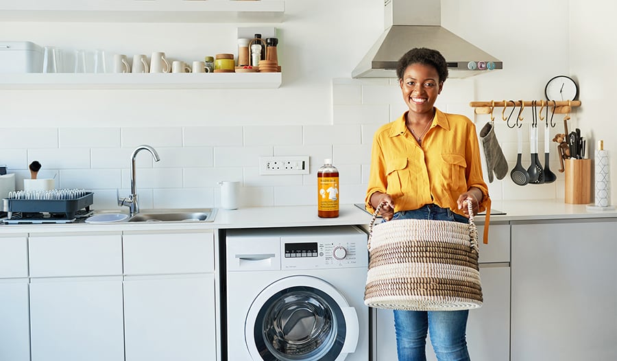 Woman doing laundry at home in bright clean kitchen