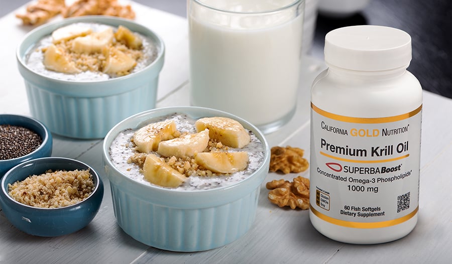 Yogurt parfaits on table with walnuts, chia seeds, and omega-3 krill oil supplement