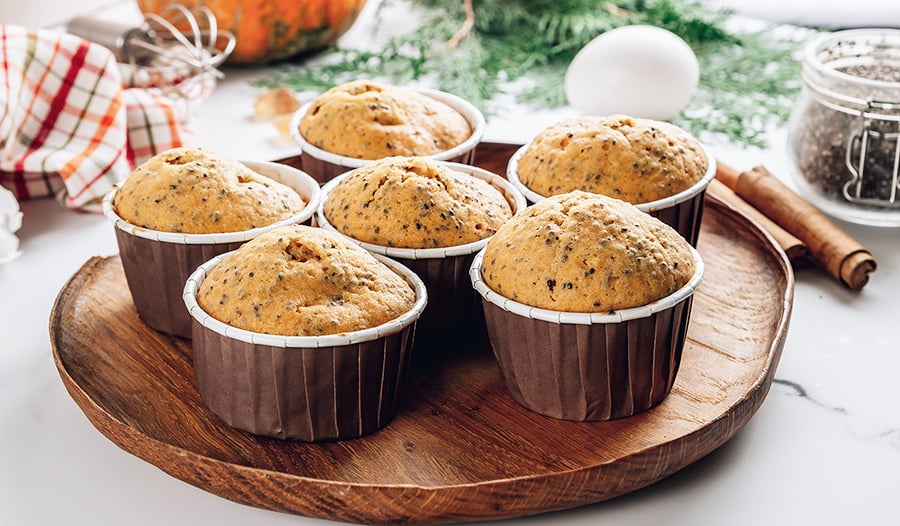 Homemade fall pumpkin muffins with chia seeds on white marble background