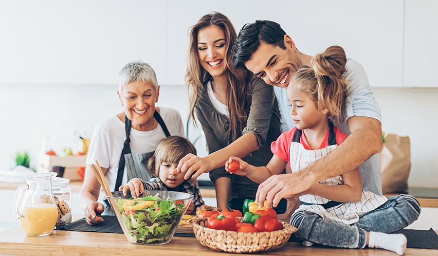 Multi-generational family cooking healthy meal in the kitchen