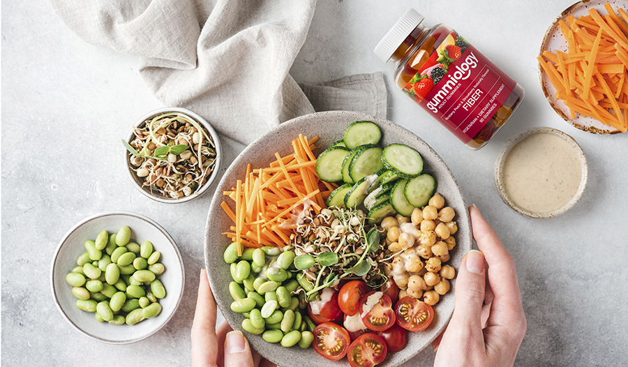 Fiber-rich salad bowl full of vegetables on table with fiber supplement