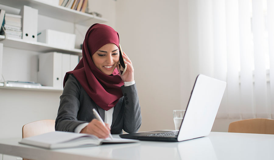 woman on the phone at work adopting habits that increase her productivity