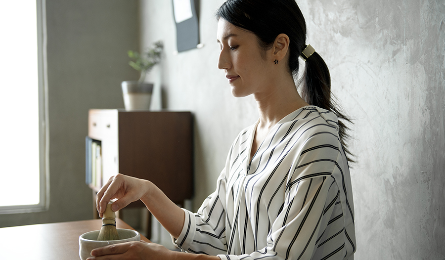 Young Asian woman making traditional matcha at home