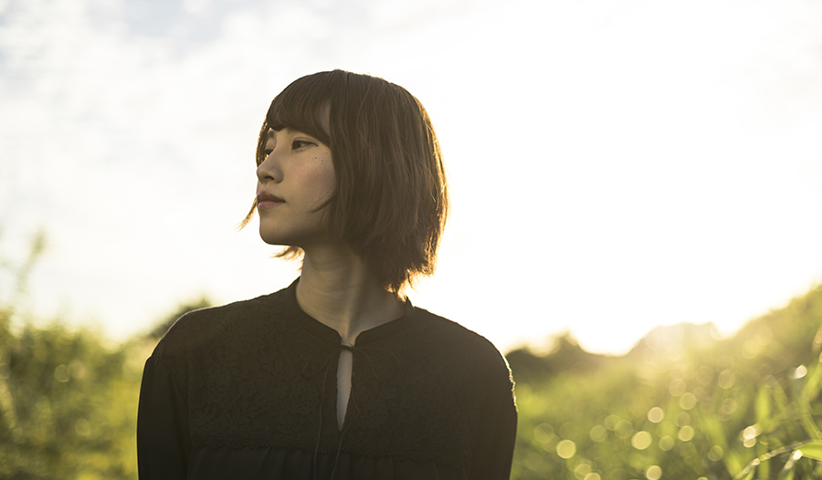 Asian girl in field at sunset