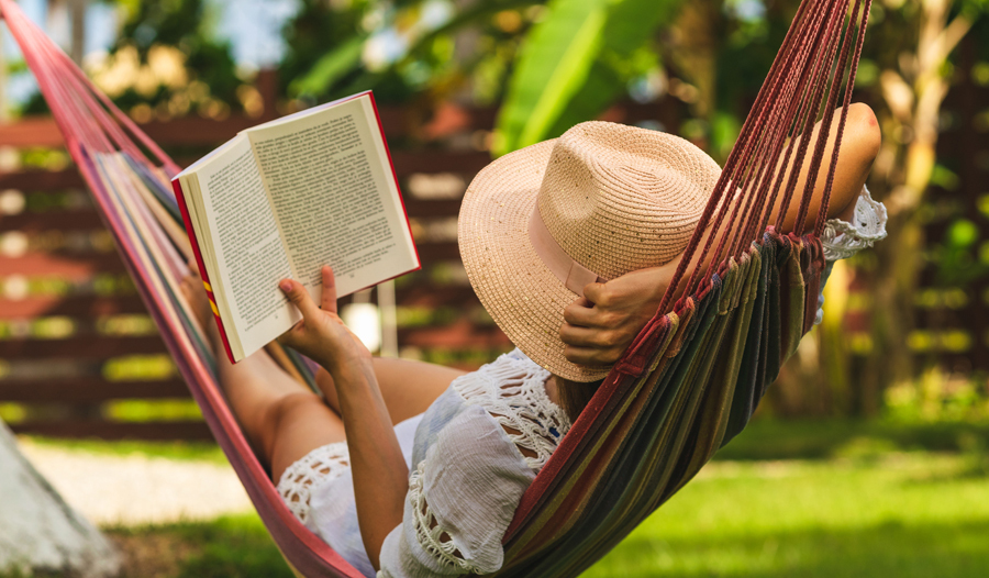 woman in hammock reading a book for self-care