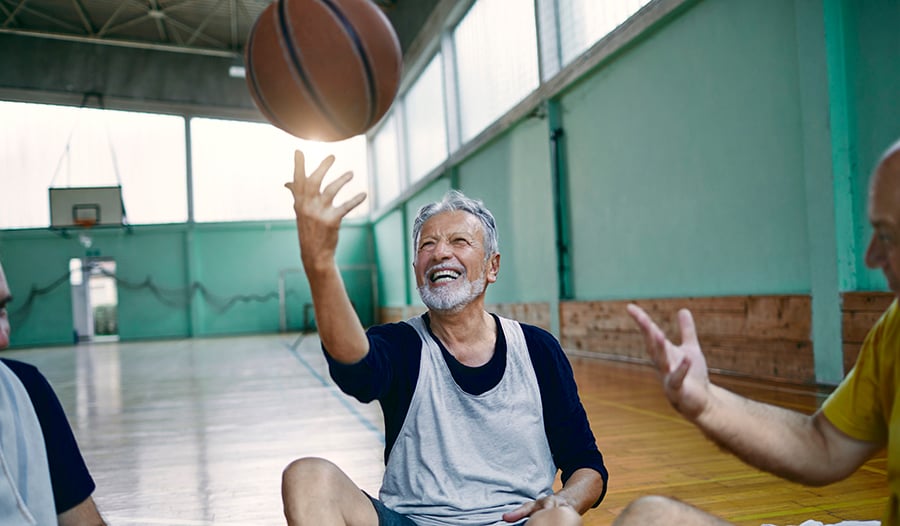 Mature male playing basketball on indoor basketball court