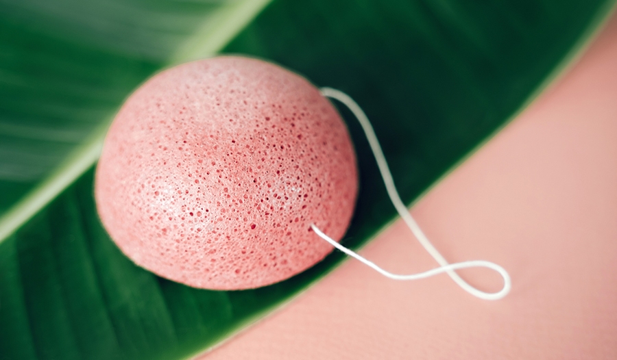 pink konjac sponge laying on top of a palm leaf