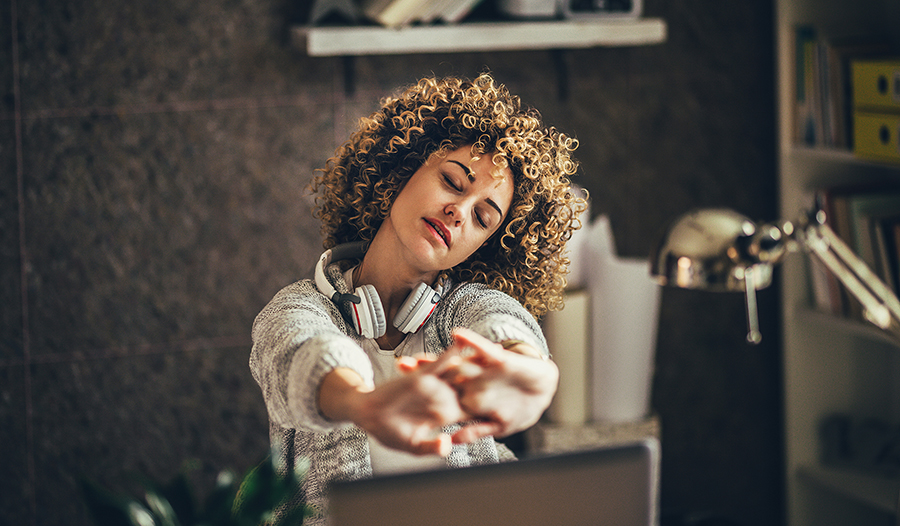 Woman stretching at her computer taking a break from work