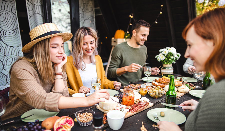 Group of friends sharing healthy cheese board 