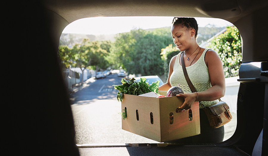 Woman putting healthy groceries in her car