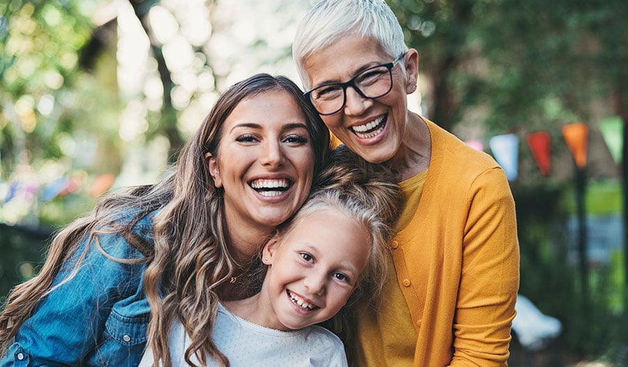 three generations of women smiling at the camera
