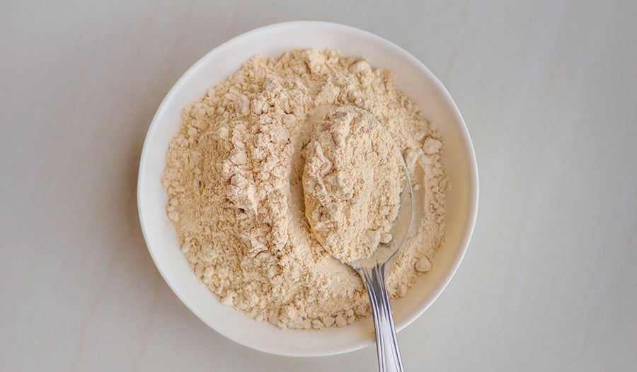 Maca root powder supplement in bowl with spoon