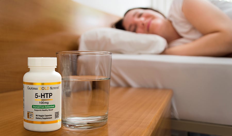 Woman sleeping with water and 5-HTP supplement on nightstand table