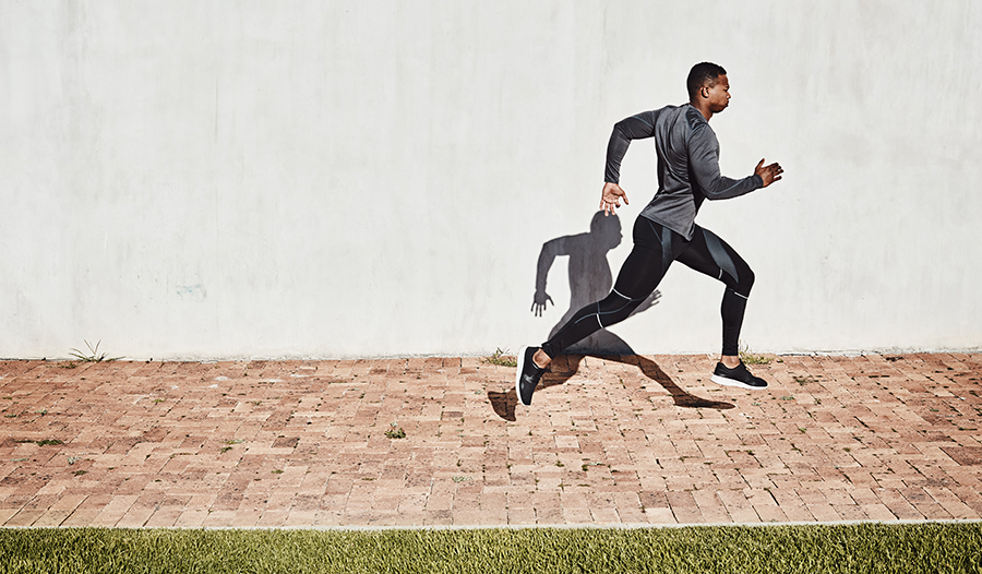 Athletic young man running on path in a park