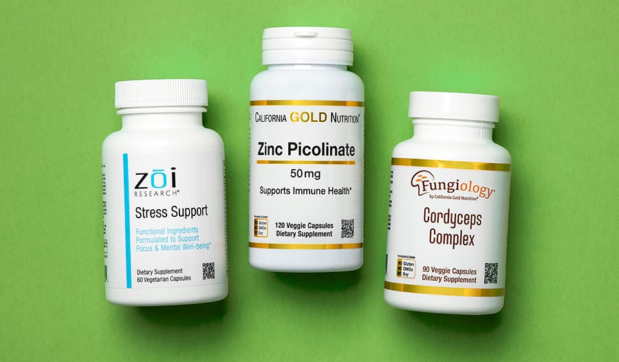 Stress support, zinc, and cordyceps supplements on green background