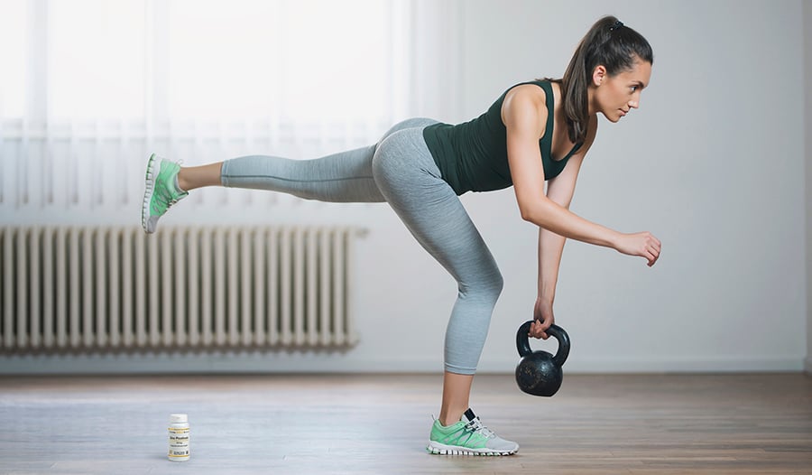 Fit woman exercising with kettlebell at home