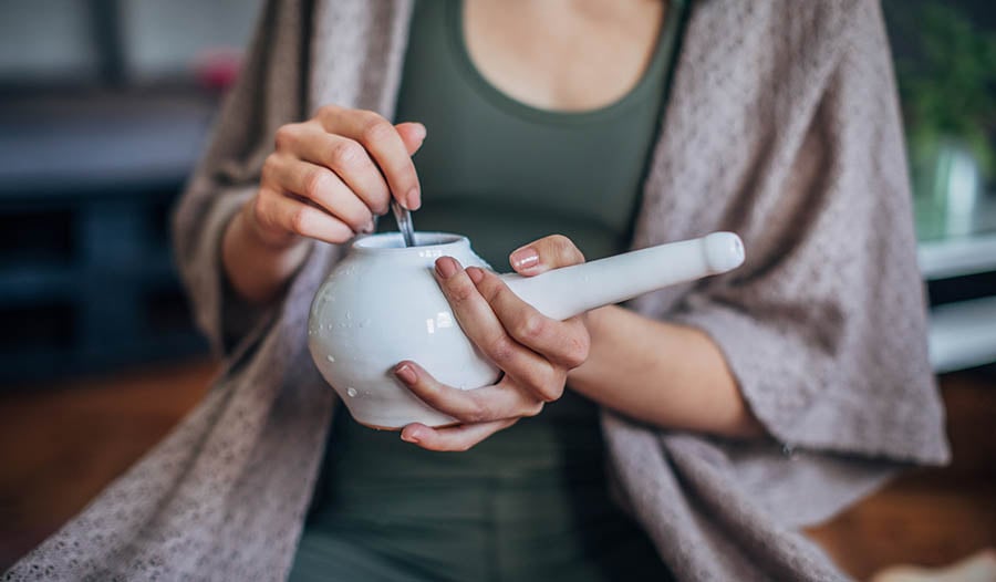 Woman sitting holding neti pot