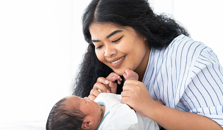 new mom looking at her baby and smiling