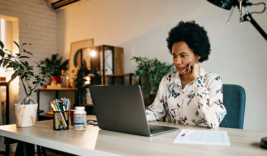 Woman working from home on a laptop while sitting at a desk