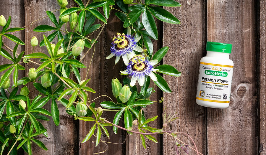 Passionflower plant on wooden table with supplement bottle