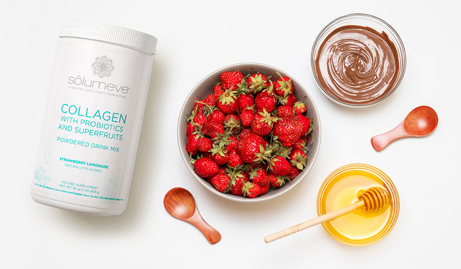 Collagen supplement bottle on white background with bowls of strawberries, chocolate, and honey