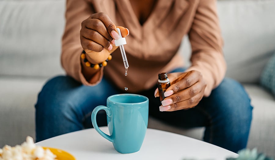 Dropping liquid vitamins into tea