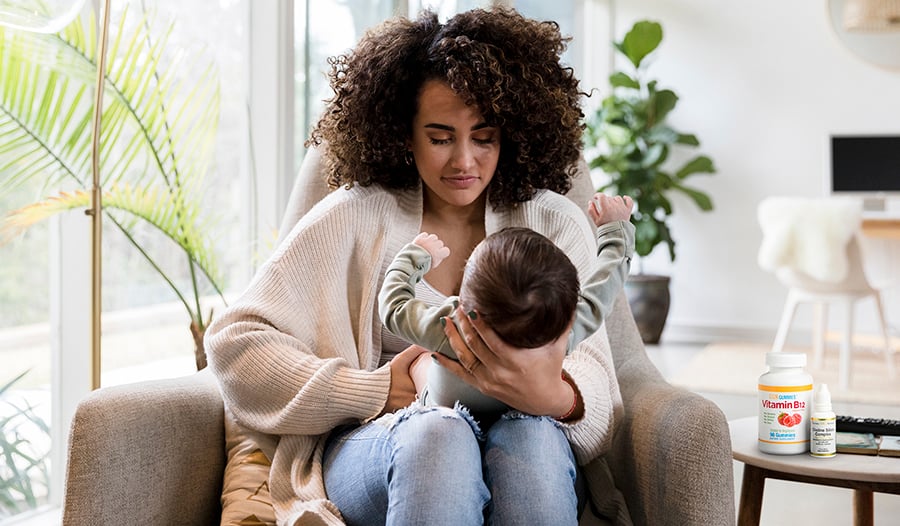 Mother feeding baby at home with vitamins on table