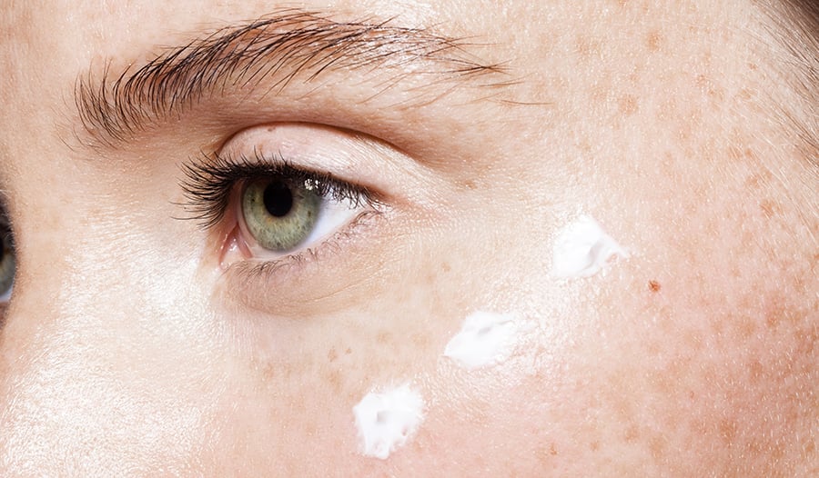 Close up of moisturizing lotion on young woman's face