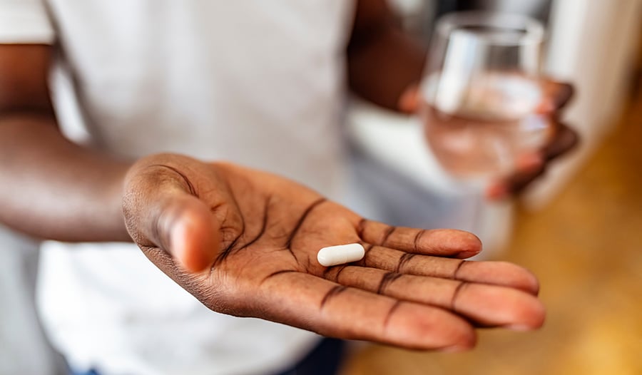 Man taking vitamins with glass of water